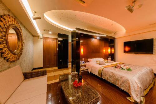 a large hotel room with a bed and a couch at HOTEL MYTH-J -ホテル マイス ジェイ- adult only in Sakaide