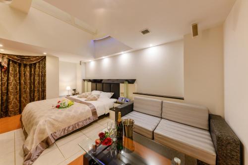 a hotel room with a bed and a couch at HOTEL MYTH-J -ホテル マイス ジェイ- adult only in Sakaide