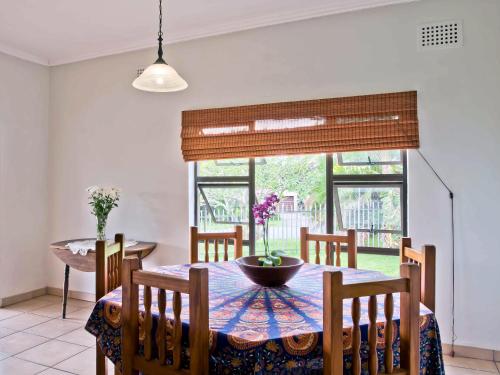 a dining room with a table and chairs and a window at 6 Margaret in Scottburgh