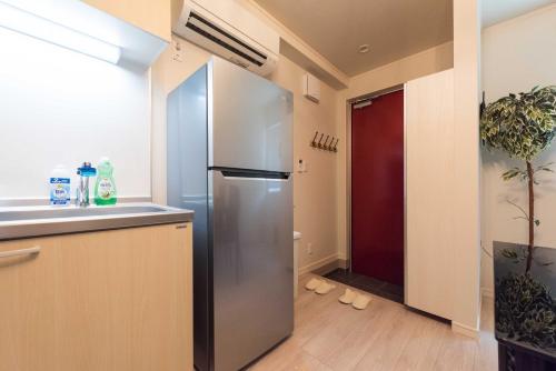 a kitchen with a stainless steel refrigerator in a room at Terrace house omori in Tokyo