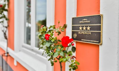 a sign on the side of a building with a flower at Hotel Stadt Kappeln in Kappeln