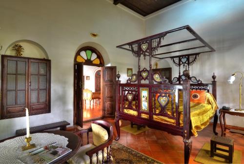 a bedroom with a large bed and a table at Raheem Residency in Alleppey