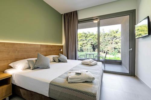 a bedroom with a bed with towels on it at White Olive Elite Laganas in Laganas