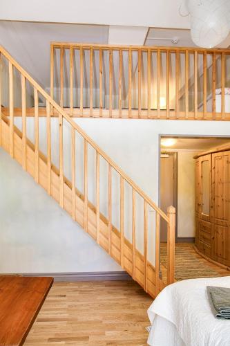 a wooden staircase in a bedroom with a bed at Kullagården in Vreta Kloster