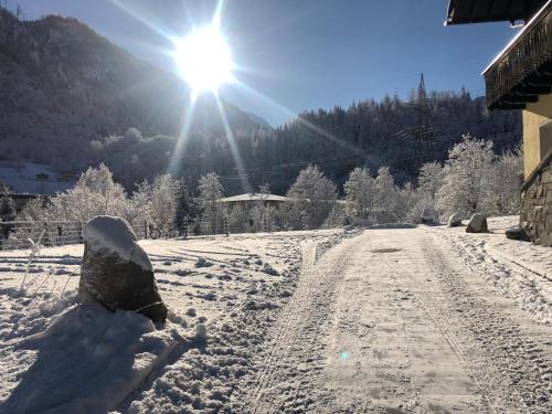 a snow covered road with the sun in the background at AlpinResort Kaprun 2 in Kaprun