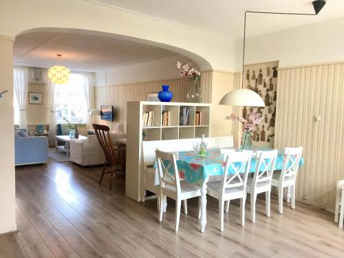 a dining room and living room with a table and chairs at Vakantiehuis Dorpsplein in Koudekerke