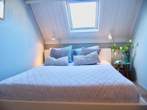 a bedroom with a bed with blue walls and a window at Vakantiehuis Dorpsplein in Koudekerke