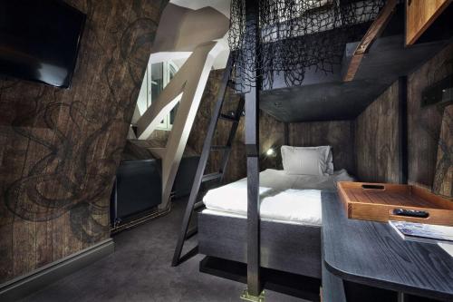 a small room with a bunk bed and a desk at Stora Hotellet; BW Premier Collection in Umeå