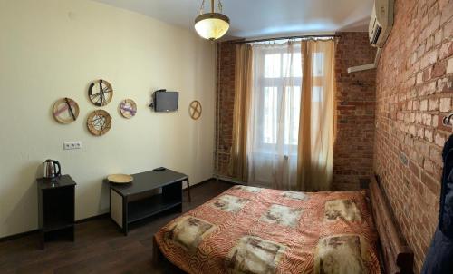 a bedroom with a bed and a brick wall at Kotsarskaya street 19 in Kharkiv