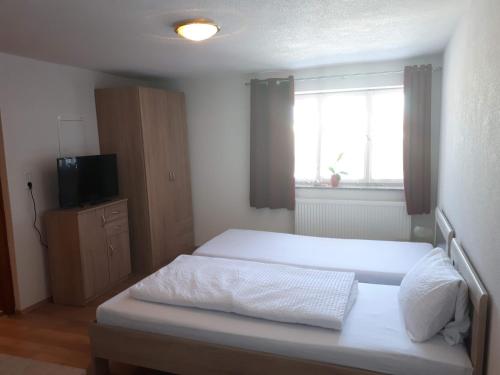 a bedroom with a bed and a television and a window at Monteurhotel B27 in Rottweil