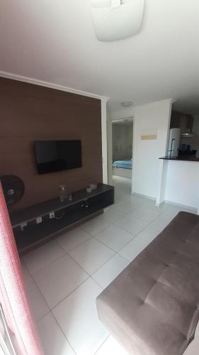 ein Wohnzimmer mit einem Flachbild-TV an der Wand in der Unterkunft OneFlat in João Pessoa