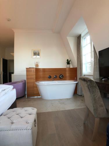 a large bathroom with a white tub in a room at The Starnbergsee Hideaway in Seeshaupt
