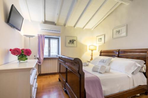 um quarto com uma cama e uma televisão na parede em Villa Collesole 12 em San Donato in Collina