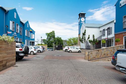 a parking lot with a clock tower in a town at Tenbergen Pension Hotel in Windhoek