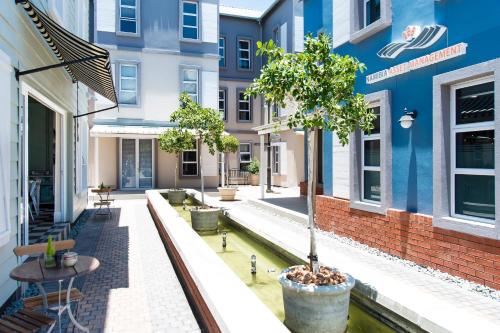 a courtyard in a building with a tree in a pot at Tenbergen Pension Hotel in Windhoek
