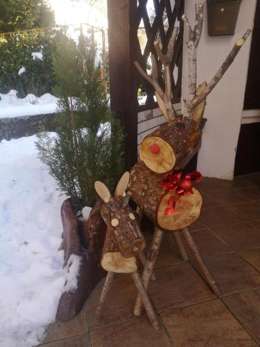 two reindeers sitting on a bench in the snow at Lukovo in Lukovo