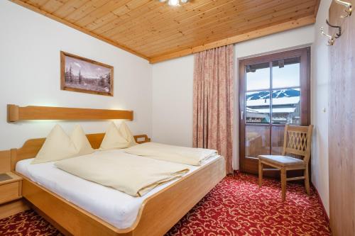 a bedroom with a bed and a window at Hotel Garni Ransburgerhof in Flachau