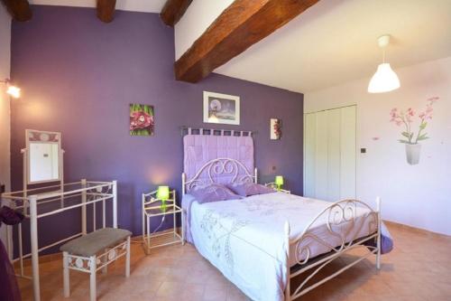 Saint-DidierにあるVilla de 3 chambres avec piscine privee jardin clos et wifi a Saint Didierの紫の壁のベッドルーム1室(ベッド1台付)