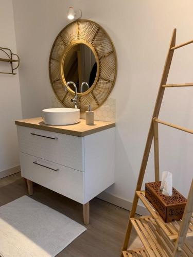 une salle de bain avec un lavabo et un miroir dans l'établissement La grange du bois, à Fresnicourt-le-Dolmen