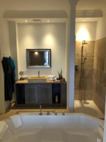 a bathroom with a tub and a sink and a shower at The Starnbergsee Hideaway in Seeshaupt
