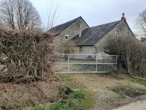 an old stone house with a fence in front of it at gîte le tilleul de la Fontaine in Alluy