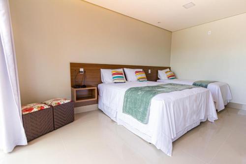 a bedroom with two beds with white sheets at Villa Tereza in Alto Paraíso de Goiás