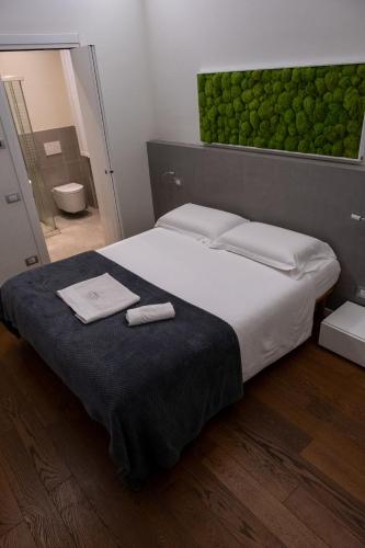 a bedroom with a large bed with two towels on it at La Corte sul Naviglio in Boffalora sopra Ticino