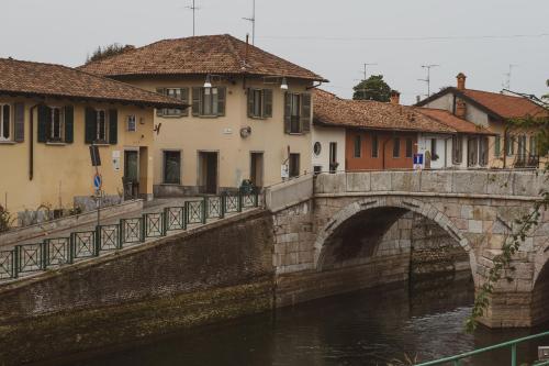 un ponte di pietra su un fiume con case ed edifici di La Corte sul Naviglio a Boffalora sopra Ticino