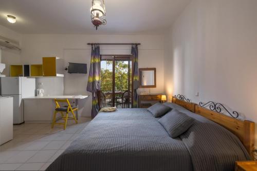 a bedroom with a large bed and a kitchen at Villa Partheniou & Garden in Syvota