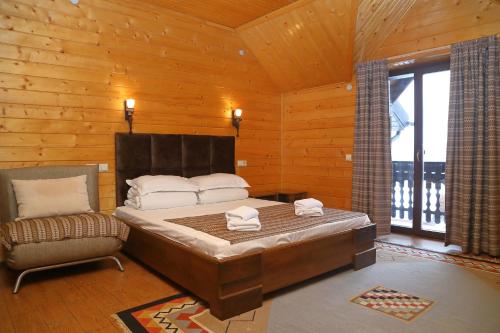 um quarto com uma cama e uma cadeira num quarto em Гук ресторанно-готельний комплекс em Bukovel
