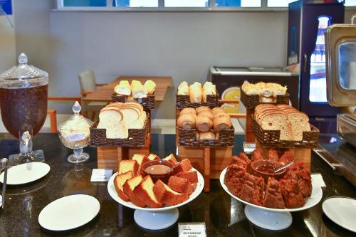 a table with several different types of bread and pastries at Transamerica Executive Campos dos Goytacazes in Campos dos Goytacazes
