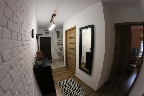a hallway of a house with a mirror and a door at APARTAMENT CENTRUM OLSZTYNA in Olsztyn