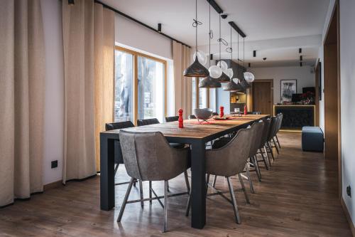 a dining room with a black table and chairs at Willa 74 Wisła in Wisła