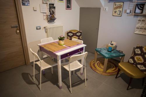 mesa pequeña y sillas en una habitación con mesa y mesa con mesa en R&B La Pomposa dei Motori, en Módena