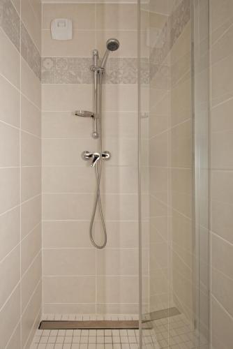 une salle de bain avec une douche avec une porte vitrée dans l'établissement Séjour chaleureux en Baie de Somme, à Saint-Valery-sur-Somme