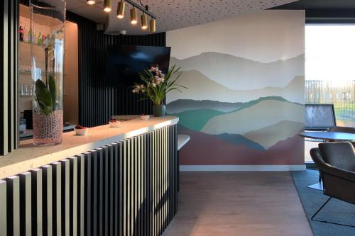 a lobby with a mural of mountains on the wall at Hôtel Akena Troyes - La Chapelle St-Luc in Troyes