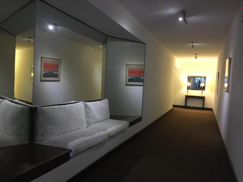 een kamer met een witte bank en een spiegel bij Punta del Este, Uruguay , Península. 2 Dormitorios in Punta del Este