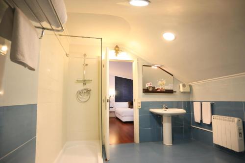 a bathroom with a toilet, sink, and shower at Hotel Conde Rodrigo 2 in Ciudad-Rodrigo