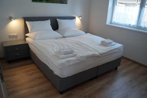 a bed in a bedroom with white sheets and pillows at FEWO Außerlechner in Innsbruck