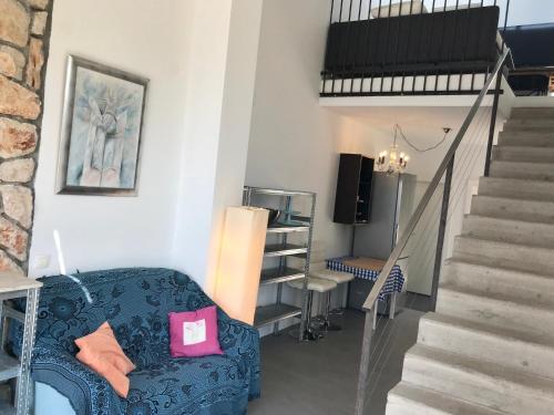 a living room with a blue couch and stairs at LOFT-Beach-apartments RATKO in Novi Vinodolski