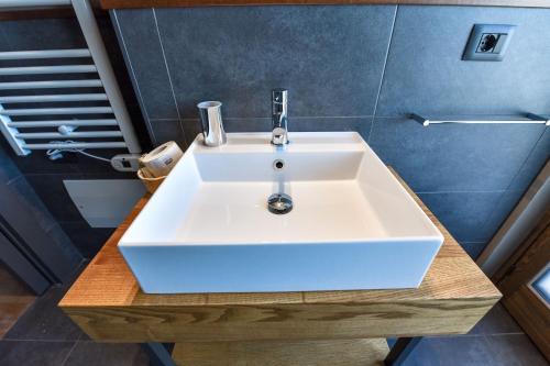 a bathroom with a white sink on a wooden table at Chalet Everest - Luxury Apartments in Prato Nevoso