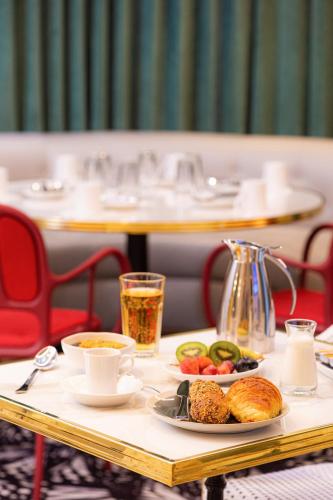 a table with plates of food and coffee on it at Mercure Paris Gare De Lyon Opera Bastille in Paris