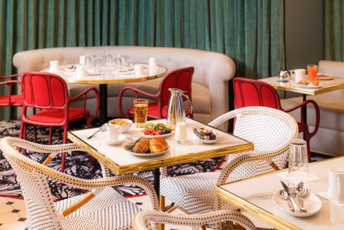 a restaurant with tables and chairs with food on them at Mercure Paris Gare De Lyon Opera Bastille in Paris
