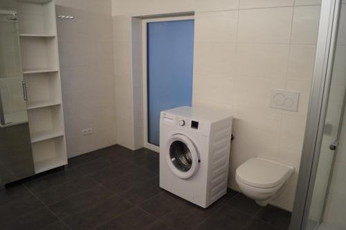 a bathroom with a washing machine and a toilet at FEWO Außerlechner in Innsbruck