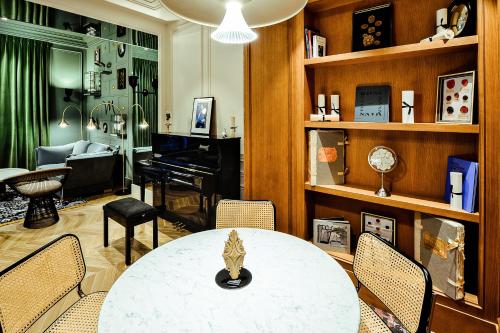 a living room with a table and chairs and a piano at Mercure Paris Gare De Lyon Opera Bastille in Paris