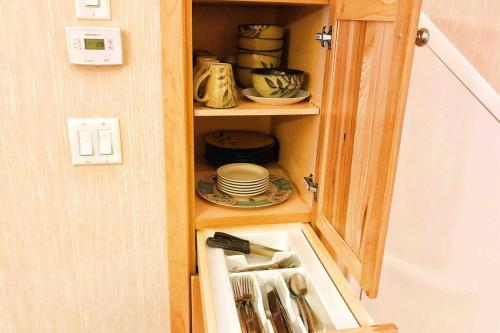 a cupboard with a sink and dishes in it at MountainView -PrivateChalet Sleep7- 5min to DT Vacation Home in Canmore