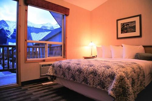 1 dormitorio con cama y ventana grande en MountainView -PrivateChalet Sleep7- 5min to DT Vacation Home, en Canmore