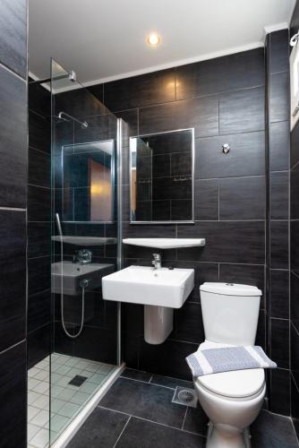 a bathroom with a toilet and a sink and a shower at Bellos Hotel Apartments in Hersonissos