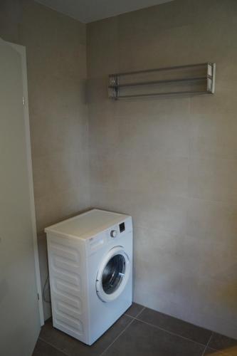 a washer and dryer in a bathroom with a wall at FEWO Außerlechner in Innsbruck