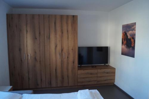 a bedroom with a tv on a wooden cabinet at FEWO Außerlechner in Innsbruck
